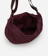 Bolso hobo negro con correa transversal ajustable y cierre en cremallera.