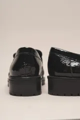 Mocasín Helen de cuero vacuno con acabado charol, color negro. Cuenta con un taco de 3,5 cm y suela de goma.