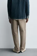 Pantalón de corte recto confeccionado en tejido de algodón con estructura twill, con bolsillos frontales y bolsillos traseros de vivo con botón.