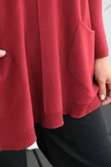 Sweater de punto color bordó, con cuello redondo, mangas largas y bolsillos frontales tipo parche. Presenta un corte holgado y diseño asimétrico con terminaciones en rib.