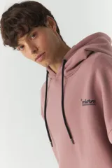 Canguro de felpa color beige con capucha, cordones negros, bolsillo tipo canguro y puños y cintura acanalados. Estampado con el logo de la marca en el pecho y parche con el logo en la manga izquierda.