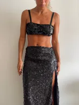 Pollera larga negra cubierta de lentejuelas, con tajo lateral alto.