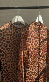 Top de microtul con estampado animal print de leopardo, doble tela, cuello alto y mangas largas.