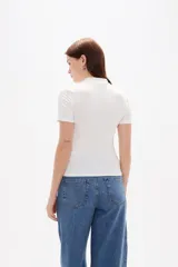 Remera de viscosa con textura acanalada, corte al cuerpo, cuello alto y mangas cortas.