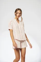 Camisa de lino a rayas verticales rojas y blancas, con cuello mao, escote en V, mangas cortas abullonadas y botones de nácar ocultos.