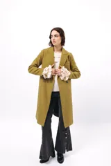 Buzo de tejido acanalado color lila, con cuello redondo decorado con dos volados y mangas largas con tres volados pequeños en los puños.
