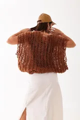 Buzo tejido a mano en lana merino color óxido, con diseño de trama calada, corte amplio y caída relajada.