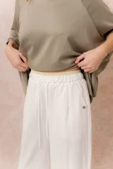 Pantalón de pierna recta color blanco off-white, de calce amplio y fluido. Posee cintura elastizada con cordón regulable y bolsillos laterales funcionales.