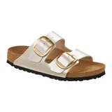 Sandalias Birkenstock modelo Arizona con diseño de dos correas anchas en color blanco perlado y hebillas grandes doradas. Posee plantilla anatómica de corcho y suela de goma antideslizante.