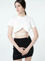 Top blanco de manga corta con cuello redondo y un diseño fruncido en el busto que deja expuesto el abdomen, atado con tiras cruzadas alrededor de la cintura.