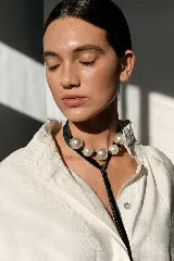 Gargantilla tipo choker compuesta por una cinta de terciopelo negro con perlas grandes engarzadas y terminación en lazo largo.