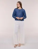 Campera corta azul de lyocell con acabado matelaseado en patrón de ondas, escote redondo, cierre frontal con cremallera y manga larga.