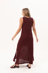 Vestido largo de tejido calado color bordó, de silueta recta, escote redondo y sin mangas, con aberturas laterales en el bajo.