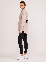 Camisa blanca de popelina oversize con cuello clásico, cierre frontal de botones y mangas largas con puños.