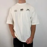 Remera de corte oversize color blanco con estampado gráfico en la espalda en color verde oliva que incluye el texto 'SOFT DISORDER' y detalles de marca.
