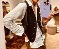 Chaleco de cuero ovino italiano color negro, con doble botonadura y detalle de pespuntes en color blanco.