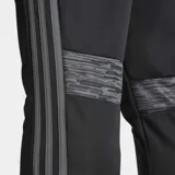 Pantalón de entrenamiento Adidas Tiro25 Essentials, color negro con logo de la marca bordado en naranja. Presenta un ajuste aerodinámico, cintura elástica con cordón y tecnología Aeroready para control de humedad.