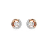 Par de aros Swarovski Dextera con baño de oro rosa. Cada aro tiene un diseño circular con una mitad cubierta de cristales transparentes y una zirconia central móvil.
