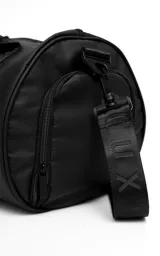 Bolso deportivo tipo duffel color negro, confeccionado en tela tracker impermeable de alta resistencia. Cuenta con compartimento lateral independiente para calzado o ropa húmeda, manijas de mano reforzadas y correa regulable extraíble. Incluye bolsillo frontal con cierre y detalles de cintas con logo grabado.