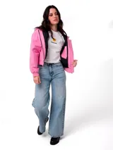 Chaqueta corta de lona color rosa, con capucha ajustable, cierre frontal y forro interior acolchado negro. Presenta un parche con el logo de la marca en el pecho.