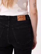 Jean de corte recto con costuras verticales decorativas en el frente, tiro medio y cierre frontal con botón metálico.