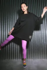 Pantalón largo de ecocuero color lila, con tiro alto, calce ajustado y botamanga irregular.