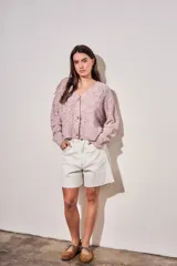Cardigan de punto texturado en color rosa viejo, con escote en V, cierre frontal de botones y mangas largas con puños acanalados.