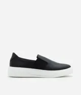 Championes tipo slip-on confeccionadas en cuero napa color negro, con elásticos laterales para un ajuste cómodo y suela robusta de goma en color blanco.