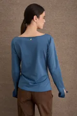 Remera de manga larga en color azul, con cuello bote y diseño ajustado al cuerpo. Presenta un acabado de borde sin costuras en el cuello y puños con abertura lateral.