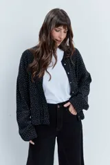Bomber de punto color negro con apliques de strass brillantes, cuello redondo, cierre frontal con botones y mangas largas.