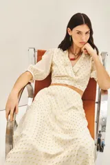 Camisa corta tipo crop top de viscosa con destellos de lurex dorado. Presenta escote en V cruzado con volados, mangas al codo con frunces en los hombros y puños elastizados.