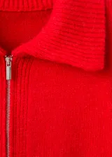 Cardigan de punto grueso color rojo, con diseño recto, cuello camisero, cierre frontal de cremallera doble y mangas largas con puños acanalados.