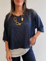 Buzo azul marino con diseño calado de manga corta y corte oversize, acompañado por una musculosa blanca básica interior.