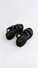 Sandalias de cuero con suela flatform track, tiras marrones y puntera con detalle de textura reptil en tono verde oliva. Cuenta con cierre de velcro en la tira trasera.