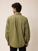 Camisa de manga larga en color blanco, confeccionada en algodón. Presenta cuello abotonado, cierre frontal con botones y un bolsillo en el pecho.