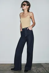 Jeans de tiro alto estilo wide leg, color marrón oscuro, con diseño de cinco bolsillos y cierre frontal de cremallera y botón metálico.