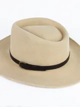 Sombrero de ala ancha confeccionado en lana color beige, con detalle de cinta de cuero marrón y hebilla metálica.
