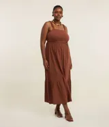 Vestido midi de Ashua confeccionado en algodón, de color marrón, con escote cuadrado, tirantes fruncidos con volados y diseño escalonado en la falda.