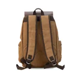 Mochila de tela canvas color negro con solapa y detalles en cuero sintético marrón. Presenta un cierre superior tipo marinero con cordón ajustable, solapa principal con correas y hebillas, y un bolsillo frontal con solapa. Posee bolsillos laterales con cierre metálico y correas de hombro ajustables.