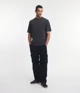 Remera de hombre, corte boxy, color gris oscuro con efecto desteñido, manga corta y cuello alto. Confeccionada en tejido de media malla (malla) de algodón.