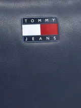Cartera bandolera de poliuretano azul marino, de diseño compacto tipo cámara, con cierre superior, correa ajustable y logo engomado de Tommy Jeans en el frente.