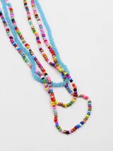 Set de tres collares confeccionados con cuentas de colores, mostacillas y cuentas facetadas translúcidas en tonos celestes, rosados, dorados y multicolor.