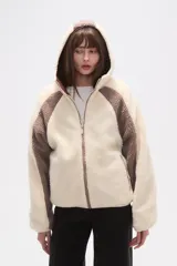 Campera de abrigo de tejido polar (tipo sherpa) color gris oscuro, con capucha y cierre frontal. Presenta paneles de color negro en los hombros y mangas, ribeteados con un vivo de color claro.