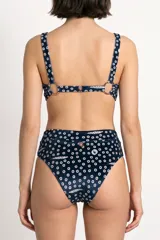 Top de bikini azul marino con estampado de círculos y pequeños peces, de escote cuadrado y tirantes anchos.