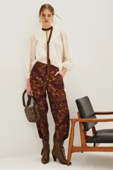 Pantalon de corte recto con estampado tipo ikat en tonos marrón y ocre, con cintura alta y bolsillos laterales.