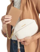 Cartera tipo bandolera de eco cuero con silueta de media luna, color beige y detalles en marrón claro. Incluye un monedero/tarjetero independiente en el bolsillo frontal y una cadena decorativa de eslabones dorados.