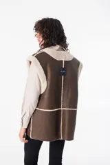 Chaleco reversible de cuero napalan color marrón con interior de corderito color crema. Tiene silueta holgada, terminaciones a la vista y bolsillos laterales.