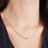 Gargantilla dorada con hilera de strass blancos y un dije central de strass blanco más grande.