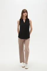 Musculosa de poliéster color blanco, con cuello en V y diseño holgado sin mangas.