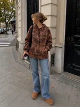 Canguro con capucha y cordones ajustables, de corte holgado y mangas largas con puños elásticos. Presenta un estampado animal print en tonos marrones y un bolsillo frontal tipo canguro con etiqueta de cuero sintético.